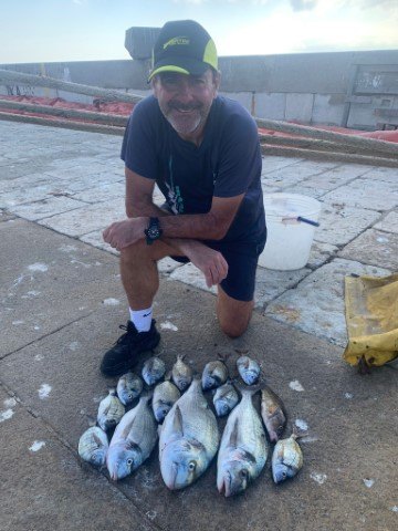 Dario Neale with his catch of three gilthead breams and other fish